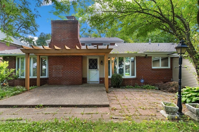 1405 1st Ave, Sterling, IL 61081 - back of property with brick siding, a chimney, a patio, and a shingled roof