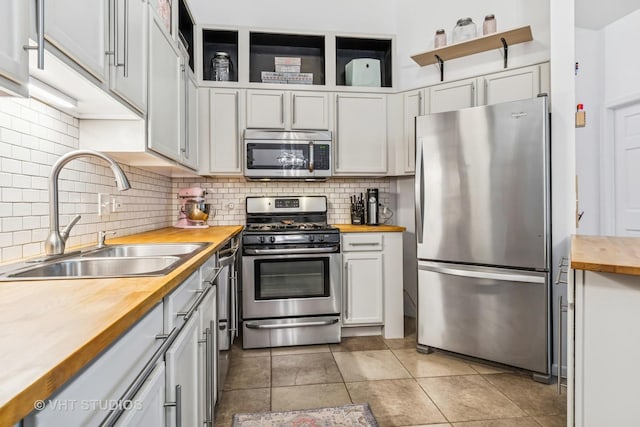 1336 Mcdowell Rd Unit 201, Naperville, IL 60563 - kitchen featuring wooden counters, appliances with stainless steel finishes, decorative backsplash, light tile patterned floors, and white cabinetry