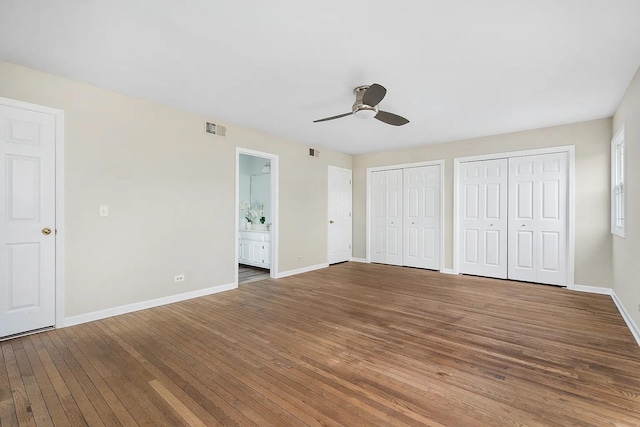 1168 Banbury Cir, Naperville, IL 60540 - unfurnished bedroom featuring wood-type flooring, two closets, connected bathroom, and a ceiling fan