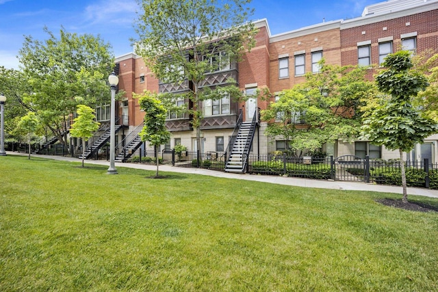 1151 W 14th Pl Unit 238, Chicago, IL 60608 - view of building exterior with stairway and a fenced front yard