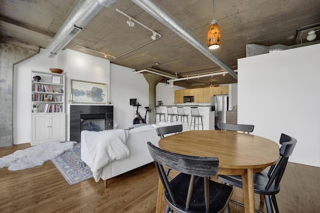 1151 W 14th Pl Unit 238, Chicago, IL 60608 - dining area featuring wood finished floors, track lighting, and a tile fireplace