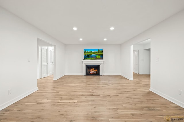 8019 S Malta Rd, Dekalb, IL 60115 - unfurnished living room with recessed lighting, light wood-style flooring, and a warm lit fireplace