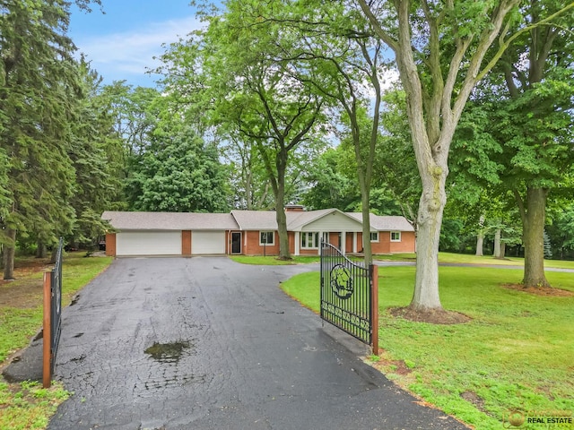 8019 S Malta Rd, Dekalb, IL 60115 - ranch-style house with an attached garage, a front yard, asphalt driveway, and view of wooded area