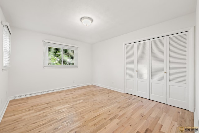 8019 S Malta Rd, Dekalb, IL 60115 - unfurnished bedroom featuring a baseboard radiator, wood finished floors, and a closet