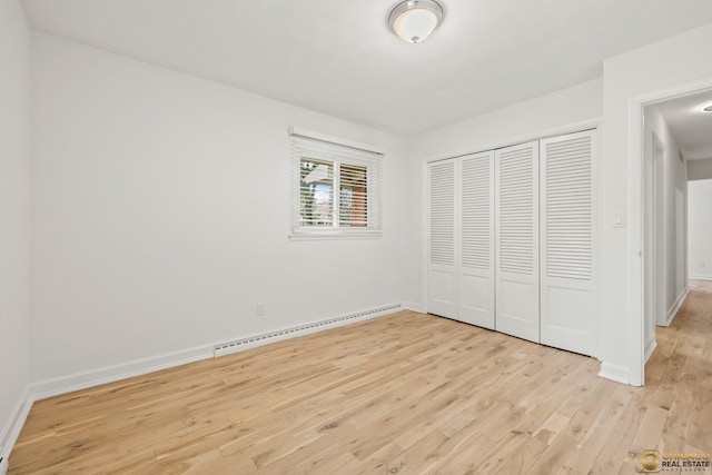 8019 S Malta Rd, Dekalb, IL 60115 - unfurnished bedroom with baseboard heating, light wood-style flooring, and a closet