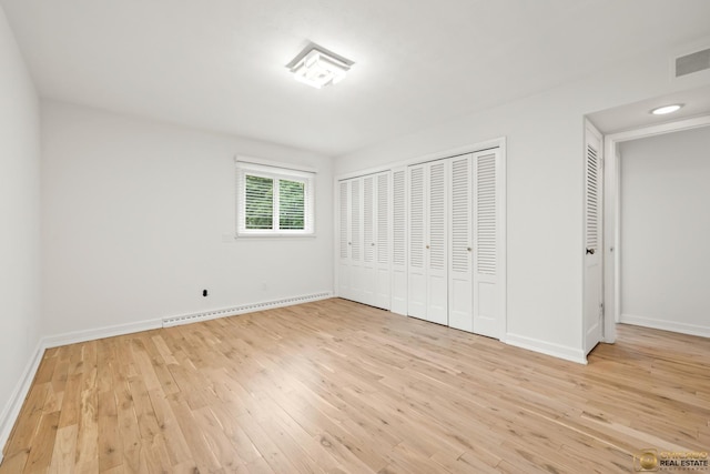 8019 S Malta Rd, Dekalb, IL 60115 - unfurnished bedroom with a baseboard heating unit and wood finished floors