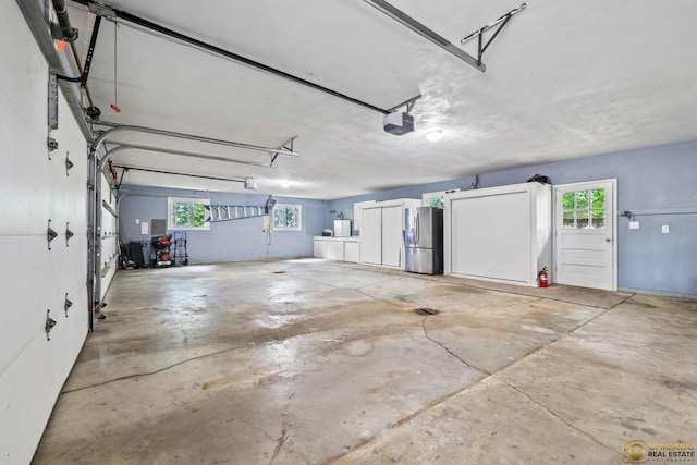 8019 S Malta Rd, Dekalb, IL 60115 - garage featuring stainless steel fridge and a garage door opener