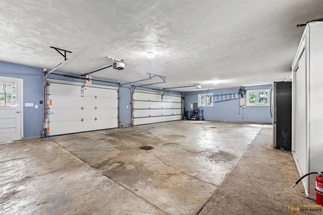 8019 S Malta Rd, Dekalb, IL 60115 - garage featuring freestanding refrigerator and a garage door opener