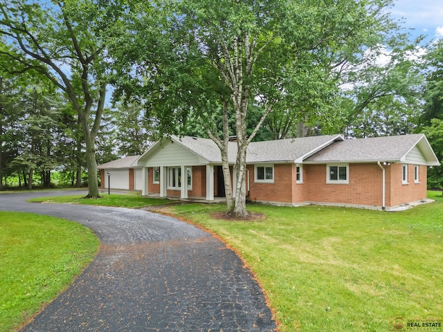 8019 S Malta Rd, Dekalb, IL 60115 - ranch-style home featuring asphalt driveway, brick siding, a front yard, and roof with shingles