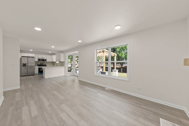 1918 Prairie Ridge Ct, Plainfield, IL 60586 - unfurnished living room featuring healthy amount of natural light, recessed lighting, light wood-style floors, and french doors