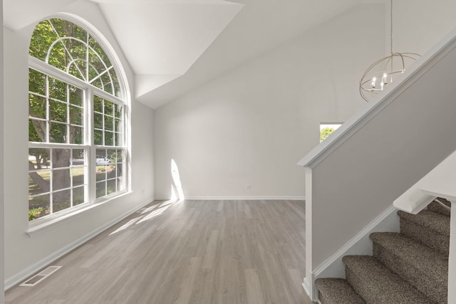 1918 Prairie Ridge Ct, Plainfield, IL 60586 - unfurnished living room featuring wood finished floors, stairway, lofted ceiling, and a chandelier