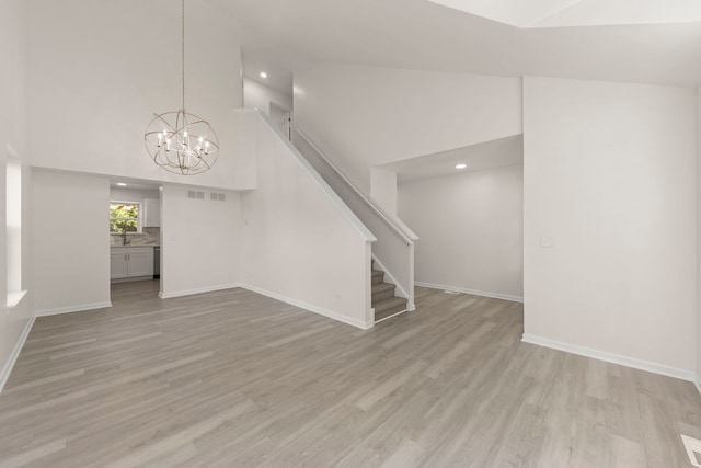 1918 Prairie Ridge Ct, Plainfield, IL 60586 - unfurnished living room with a chandelier, high vaulted ceiling, light wood finished floors, stairs, and recessed lighting