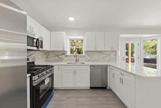 1918 Prairie Ridge Ct, Plainfield, IL 60586 - kitchen with stainless steel appliances, a peninsula, light countertops, white cabinets, and light wood-style flooring