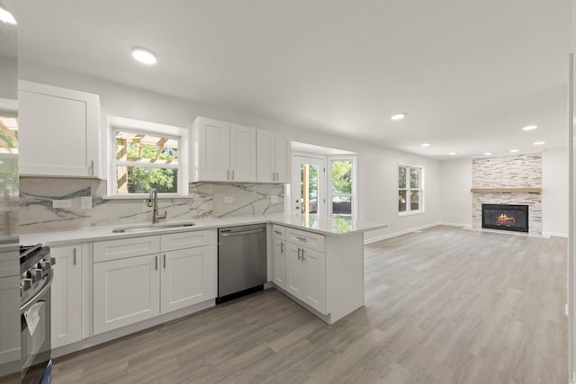 1918 Prairie Ridge Ct, Plainfield, IL 60586 - kitchen featuring appliances with stainless steel finishes, light wood-style floors, a peninsula, light countertops, and white cabinetry