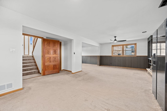 13301 Maverick Trl, Homer Glen, IL 60491 - unfurnished living room featuring a wainscoted wall, a ceiling fan, carpet flooring, stairs, and wood walls