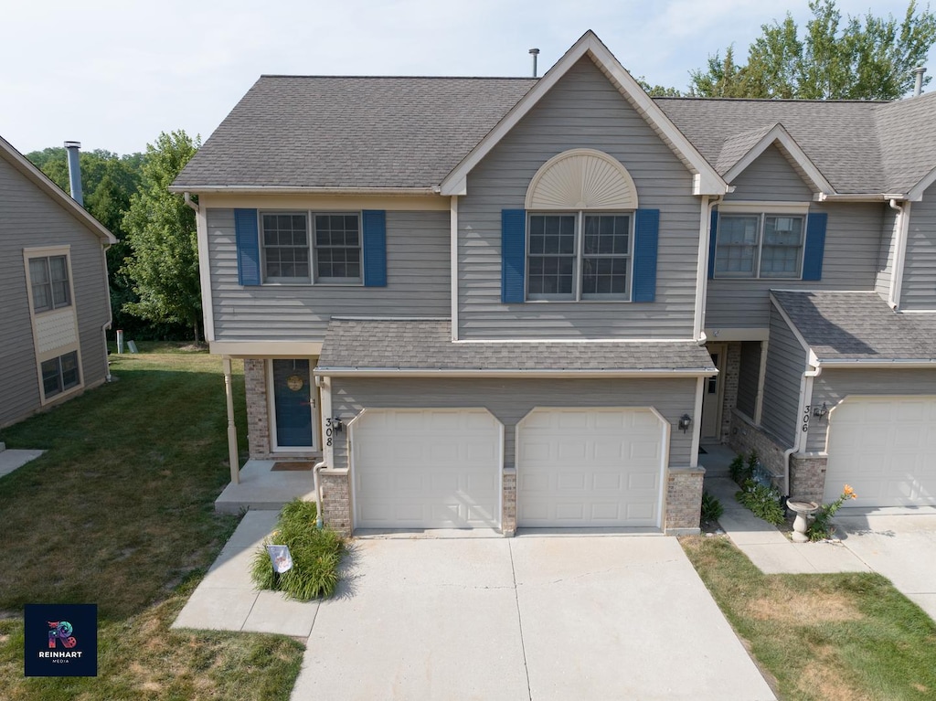 308 River Bluff Dr, Carpentersville, IL 60110 - view of front of property featuring driveway, a front lawn, an attached garage, and roof with shingles