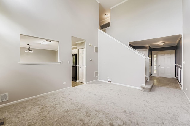 504 Lancaster Dr, Pingree Grove, IL 60140 - unfurnished living room featuring stairs, ornamental molding, carpet flooring, and a high ceiling