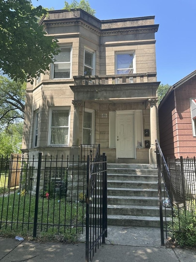 5320 S Carpenter St, Chicago, IL 60609 - view of front facade with a fenced front yard, stone siding, a gate, and a balcony