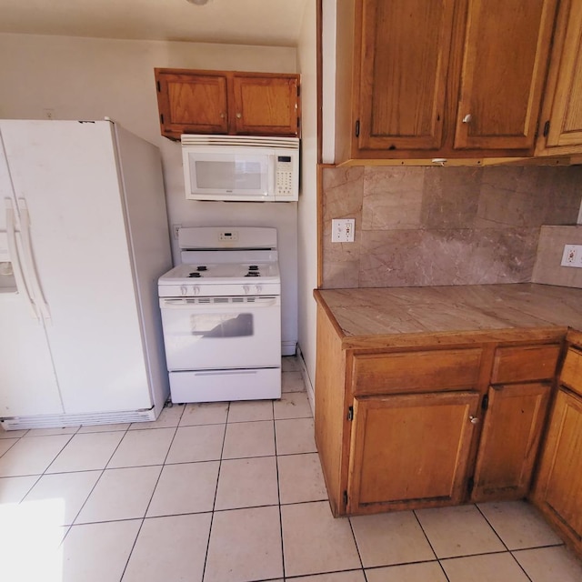 7542 S Prairie Ave, Chicago, IL 60619 - kitchen featuring white appliances, brown cabinetry, decorative backsplash, light tile patterned floors, and tile countertops