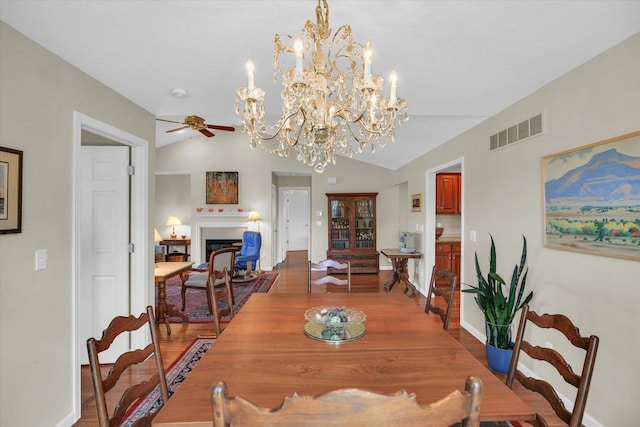 1906 Lydia Ct Unit A, Urbana, IL 61802 - dining space with a ceiling fan, wood finished floors, a chandelier, a fireplace, and vaulted ceiling