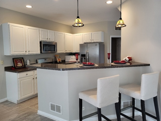 2949 Brossman St, Naperville, IL 60564 - kitchen featuring stainless steel appliances, dark countertops, a peninsula, a breakfast bar area, and recessed lighting