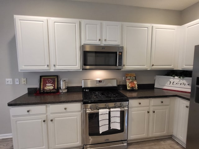 2949 Brossman St, Naperville, IL 60564 - kitchen featuring appliances with stainless steel finishes, dark countertops, white cabinetry, and light wood finished floors