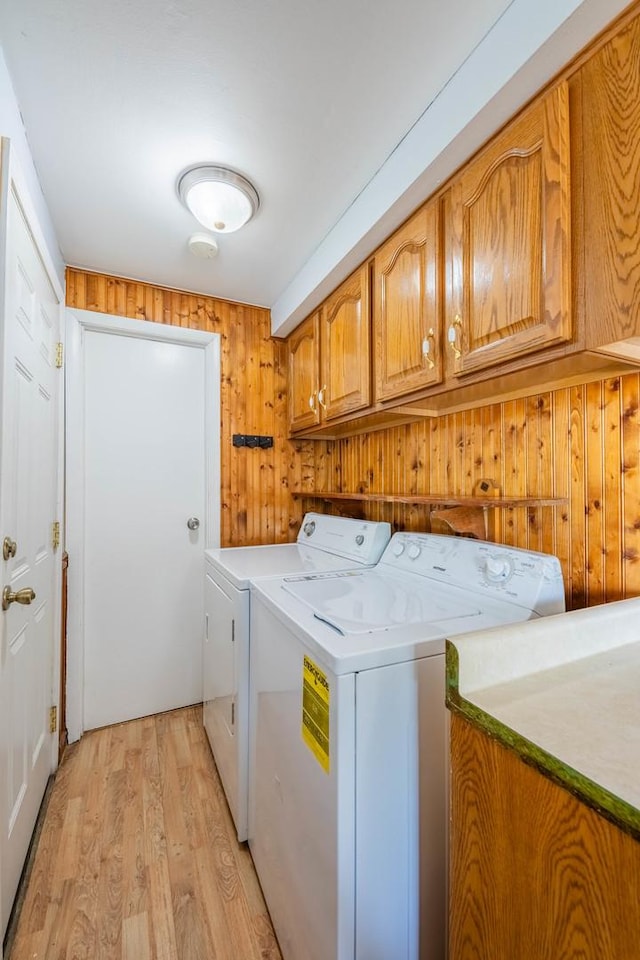 100 Patricia Dr, Schaumburg, IL 60193 - laundry area featuring cabinet space, independent washer and dryer, light wood-style flooring, and wooden walls