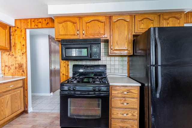 100 Patricia Dr, Schaumburg, IL 60193 - kitchen featuring black appliances, brown cabinetry, light countertops, backsplash, and light tile patterned floors