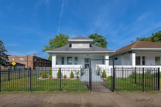 11956 S Harvard Ave, Chicago, IL 60628 - view of front facade featuring covered porch, a fenced front yard, and a shingled roof