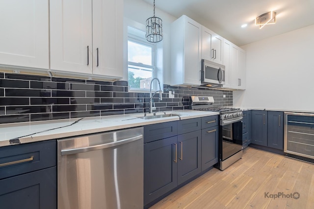 11956 S Harvard Ave, Chicago, IL 60628 - kitchen featuring stainless steel appliances, wine cooler, white cabinetry, light stone counters, and decorative backsplash