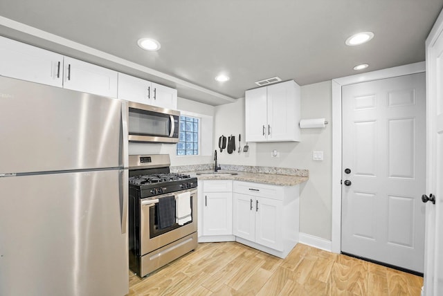 1652 S Ridgeway Ave, Chicago, IL 60623 - kitchen featuring appliances with stainless steel finishes, white cabinets, recessed lighting, light stone counters, and light wood finished floors