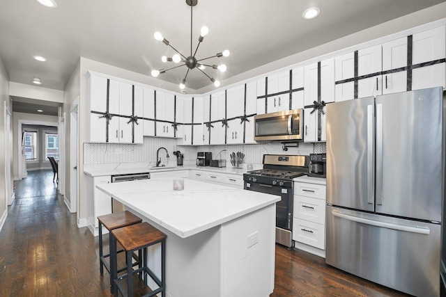 1652 S Ridgeway Ave, Chicago, IL 60623 - kitchen with appliances with stainless steel finishes, dark wood-style floors, tasteful backsplash, a kitchen island, and recessed lighting