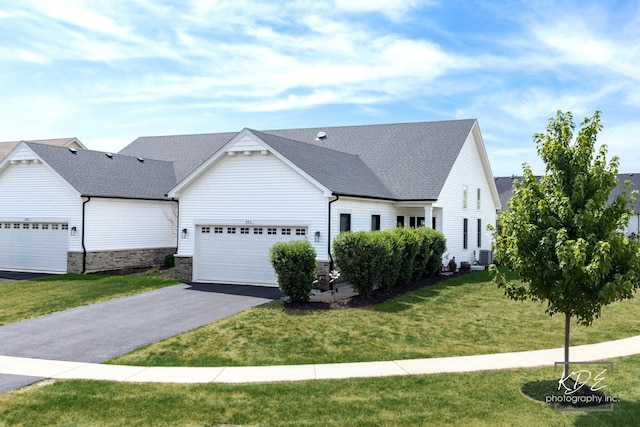 561 Sudbury Cir, Oswego, IL 60543 - view of front of property featuring an attached garage, asphalt driveway, a front yard, and stone siding