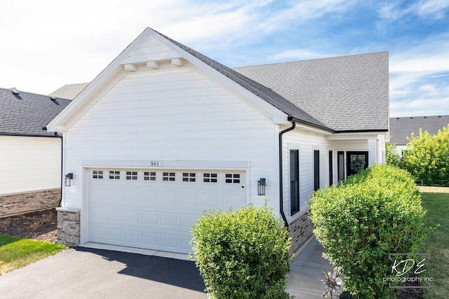 561 Sudbury Cir, Oswego, IL 60543 - view of home's exterior with a garage, asphalt driveway, and roof with shingles