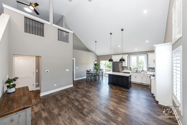 561 Sudbury Cir, Oswego, IL 60543 - kitchen with high vaulted ceiling, freestanding refrigerator, a center island, ceiling fan, and light countertops