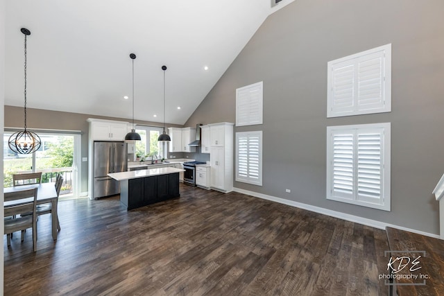 561 Sudbury Cir, Oswego, IL 60543 - kitchen with stainless steel appliances, high vaulted ceiling, a center island, a chandelier, and light countertops