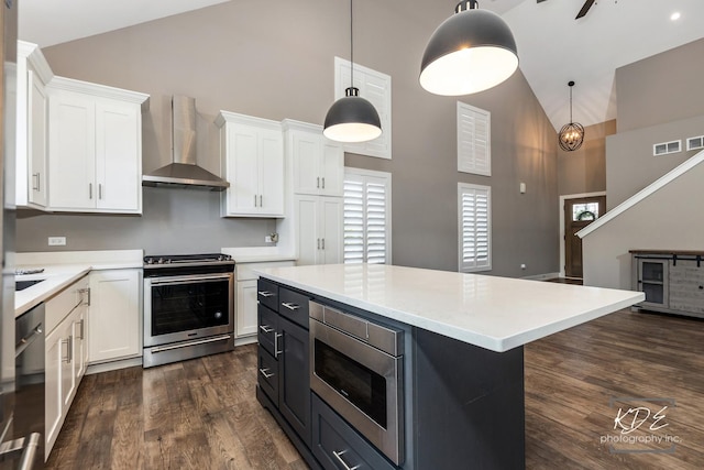 561 Sudbury Cir, Oswego, IL 60543 - kitchen with appliances with stainless steel finishes, high vaulted ceiling, wall chimney range hood, white cabinets, and light countertops