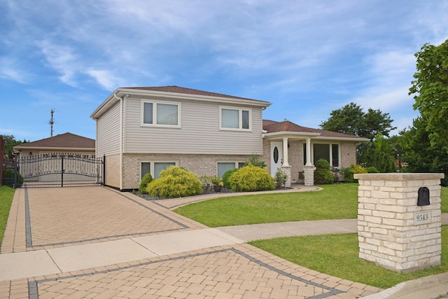 9343 170th Pl, Orland Hills, IL 60487 - tri-level home featuring a gate, a front lawn, brick siding, decorative driveway, and a garage