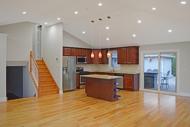 9343 170th Pl, Orland Hills, IL 60487 - kitchen featuring appliances with stainless steel finishes, a kitchen island, light wood-style flooring, decorative backsplash, and pendant lighting