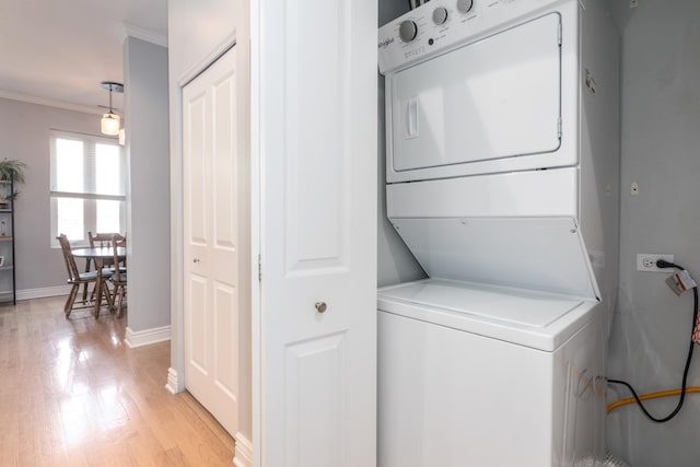 2409 W Catalpa Ave Unit 307, Chicago, IL 60625 - laundry area featuring stacked washer and clothes dryer, crown molding, and light wood-style floors