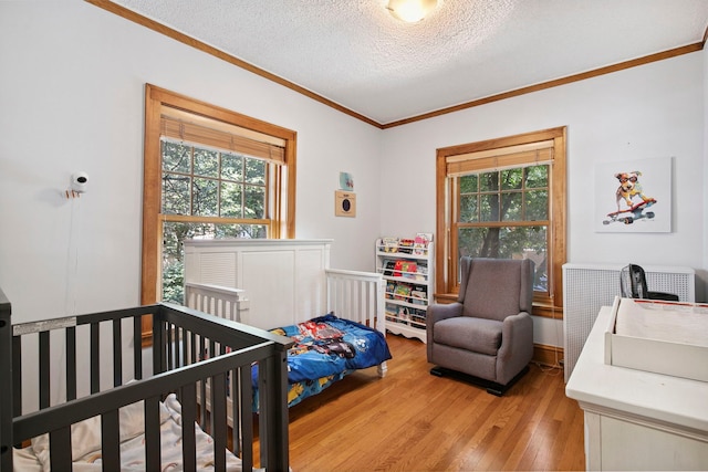 542 W Brompton Ave Unit 1S, Chicago, IL 60657 - bedroom featuring ornamental molding, multiple windows, light wood finished floors, and a textured ceiling
