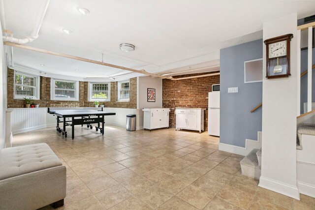 542 W Brompton Ave Unit 1S, Chicago, IL 60657 - recreation room featuring brick wall and baseboards