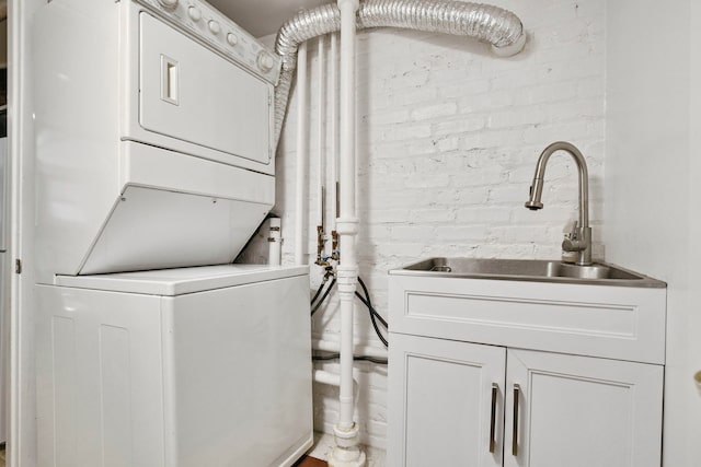 542 W Brompton Ave Unit 1S, Chicago, IL 60657 - laundry area with estacked washer and dryer, brick wall, and cabinet space