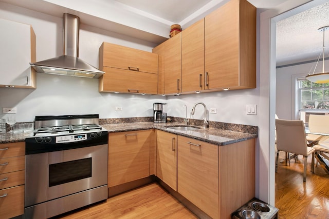 542 W Brompton Ave Unit 1S, Chicago, IL 60657 - kitchen featuring stainless steel gas stove, wall chimney range hood, light wood-style flooring, and dark stone countertops