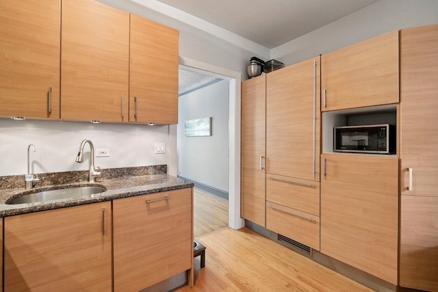 542 W Brompton Ave Unit 1S, Chicago, IL 60657 - kitchen with black microwave, light wood-style flooring, and dark stone counters