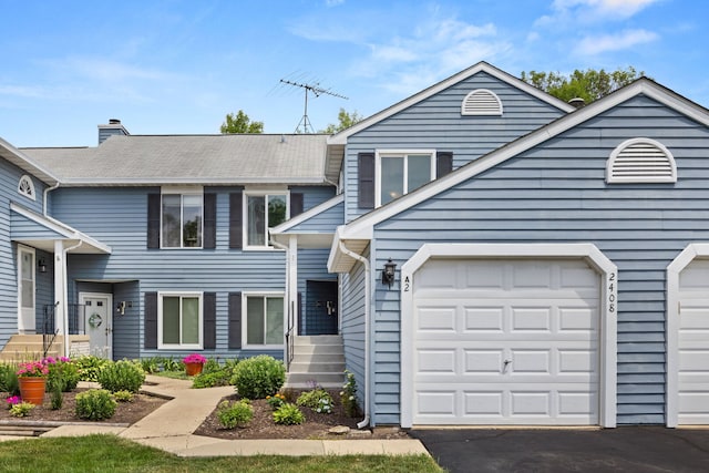 2408 Danbury Dr Unit A2, Woodridge, IL 60517 - view of front facade featuring a garage, a chimney, and asphalt driveway