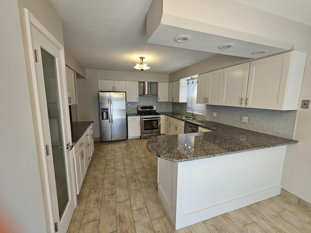 7215 Beckwith Rd, Morton Grove, IL 60053 - kitchen with stainless steel appliances, wall chimney range hood, a peninsula, decorative backsplash, and dark stone counters
