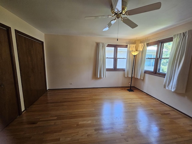 7215 Beckwith Rd, Morton Grove, IL 60053 - unfurnished bedroom with wood finished floors, multiple windows, and ceiling fan