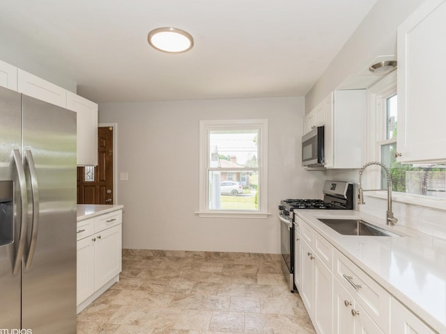 2402 Marshall Pkwy, Waukegan, IL 60085 - kitchen with stainless steel appliances, light countertops, healthy amount of natural light, and white cabinets