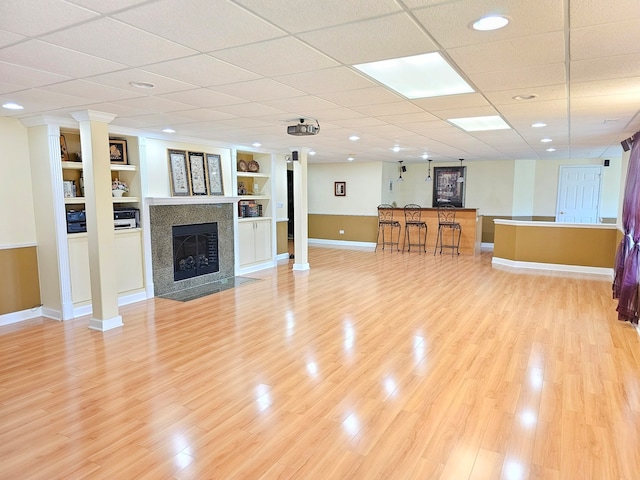 4 Forest View Dr, Hawthorn Woods, IL 60047 - unfurnished living room with a tiled fireplace, light wood-style flooring, bar, and built in features
